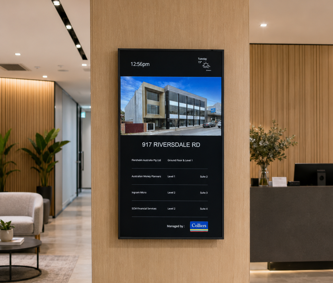 Digital directory mounted on a wooden column in a modern lobby, showing 917 Riversdale Rd and office listings